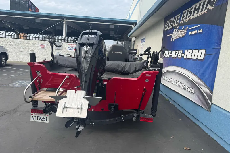 Slide: The Image of 2021 Lund 1650 Angler SS boat with motor, parked near a marine store. - 6