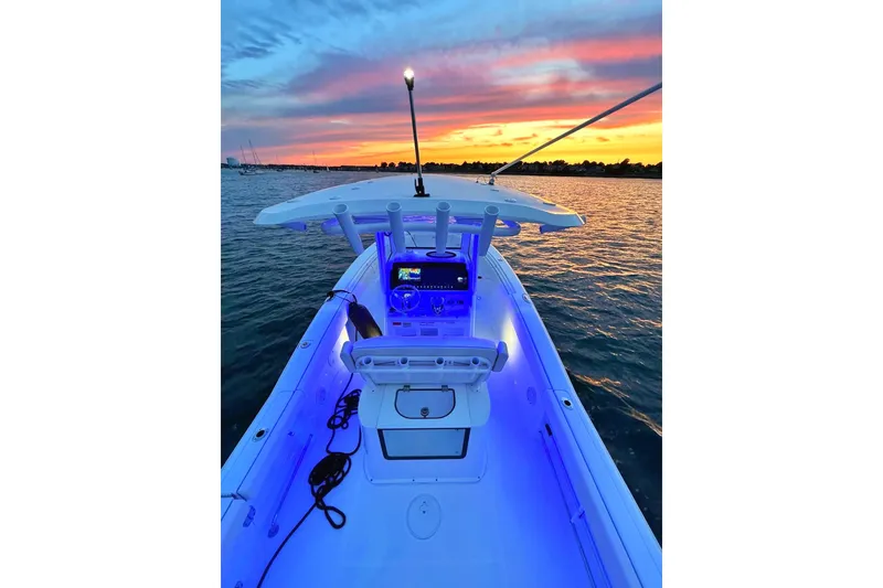 Slide: The Image of 2024 Sea Hunt Gamefish 25 boat with Yamaha engines, illuminated at night in a marina. - 3