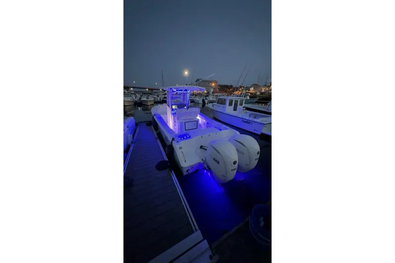 Slide: The Image of 2024 Sea Hunt Gamefish 25 boat cockpit with illuminated controls at sunset. - 5