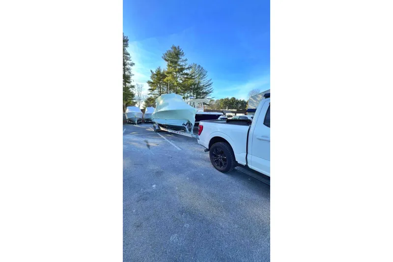 Slide: The Image of 2024 Sea Hunt Gamefish 25 boat on trailer, parked beside a white truck. - 6