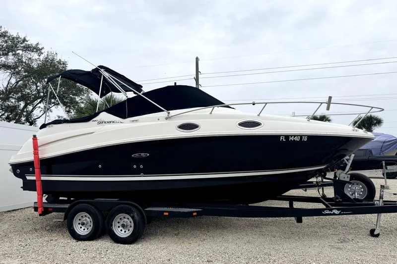 The Image of 2007 Sea Ray 240 Sundancer boat on trailer, parked outdoors. - 0