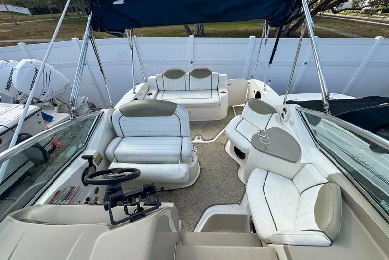 Slide: The Image of 2007 Sea Ray 240 Sundancer boat interior with white seating and steering wheel. - 100