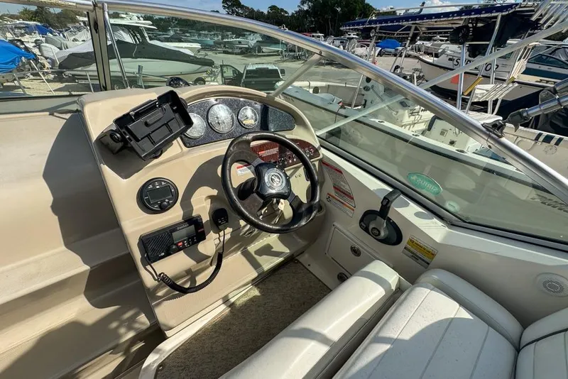 Slide: The Image of 2007 Sea Ray 240 Sundancer boat cockpit with steering wheel and control panel. - 109