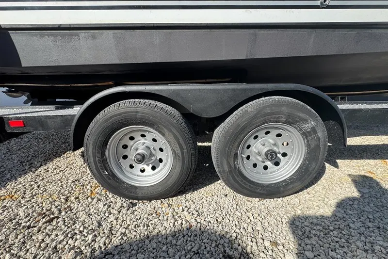 Slide: The Image of Trailer wheels of a 2007 Sea Ray 240 Sundancer boat on gravel surface. - 128