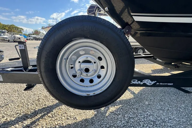 Slide: The Image of Trailer wheel of a 2007 Sea Ray 240 Sundancer boat on gravel lot. - 130