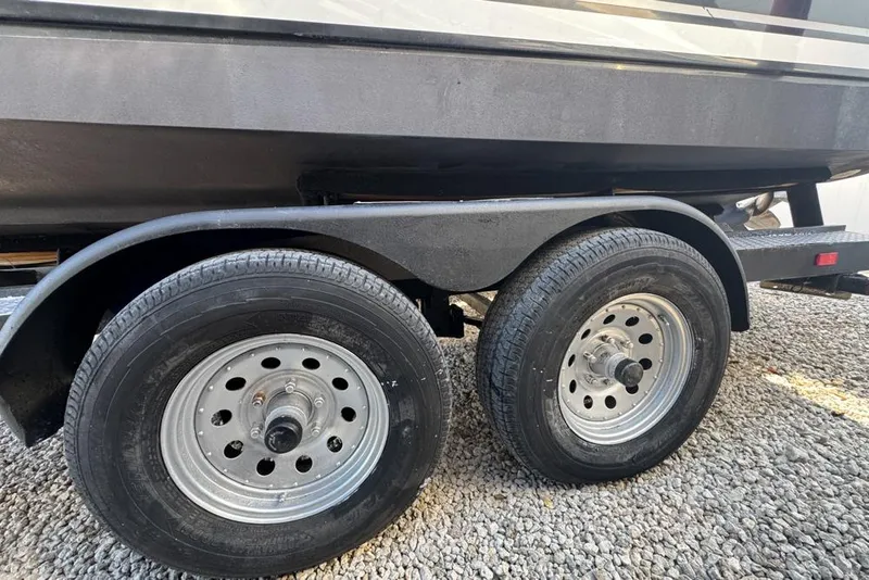 Slide: The Image of Trailer wheels of a 2007 Sea Ray 240 Sundancer on gravel surface. - 134