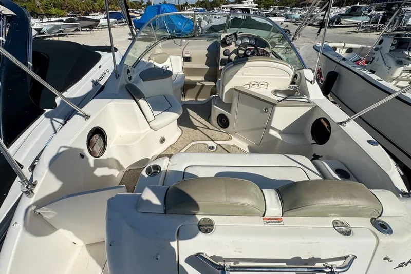 Slide: The Image of 2007 Sea Ray 240 Sundancer boat interior with seating and helm, docked at marina. - 17