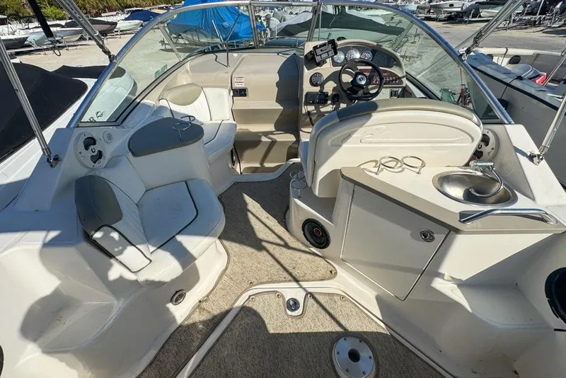 Slide: The Image of 2007 Sea Ray 240 Sundancer boat interior with seating, steering, and sink. - 22