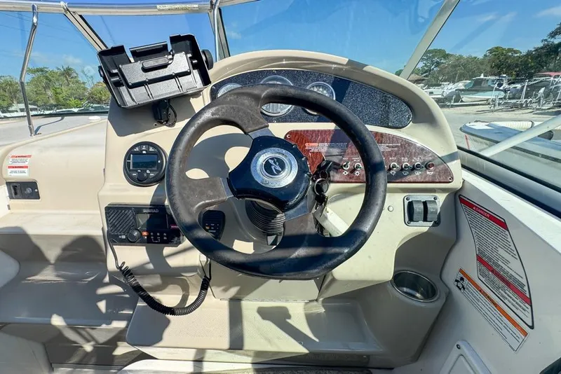Slide: The Image of 2007 Sea Ray 240 Sundancer helm with steering wheel and control panel. - 37