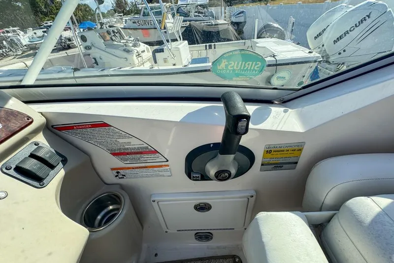 Slide: The Image of 2007 Sea Ray 240 Sundancer cockpit with control panel and throttle lever. - 38
