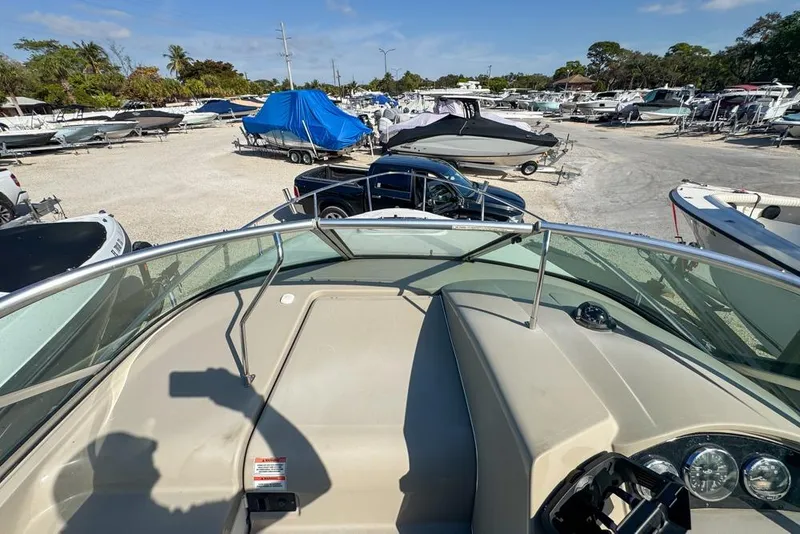 Slide: The Image of 2007 Sea Ray 240 Sundancer boat in a marina, surrounded by other boats and trailers. - 48
