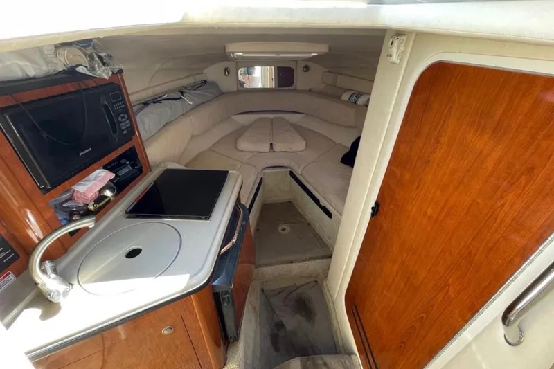 Slide: The Image of 2007 Sea Ray 240 Sundancer cabin interior with kitchenette and cozy seating area. - 56