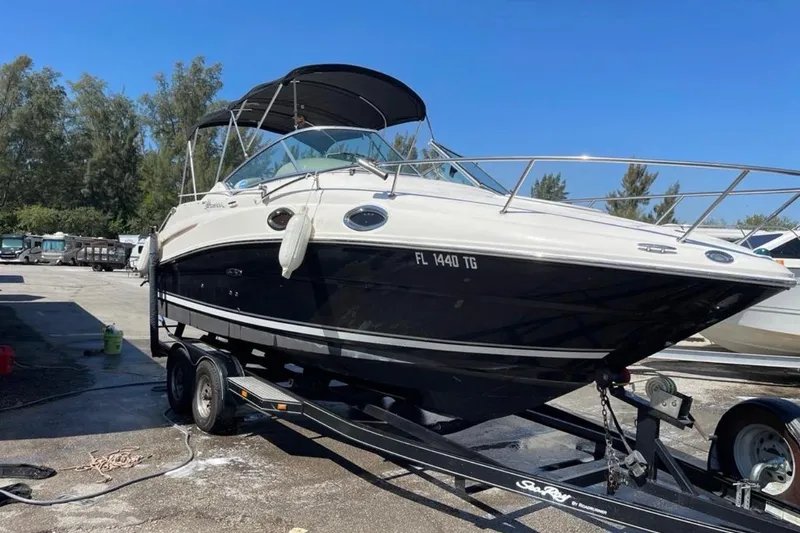 Slide: The Image of 2007 Sea Ray 240 Sundancer boat on trailer, parked outdoors under a blue sky. - 6
