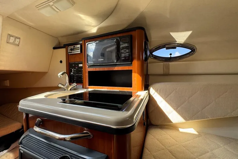 Slide: The Image of 2007 Sea Ray 240 Sundancer cabin interior with kitchenette and seating area. - 67