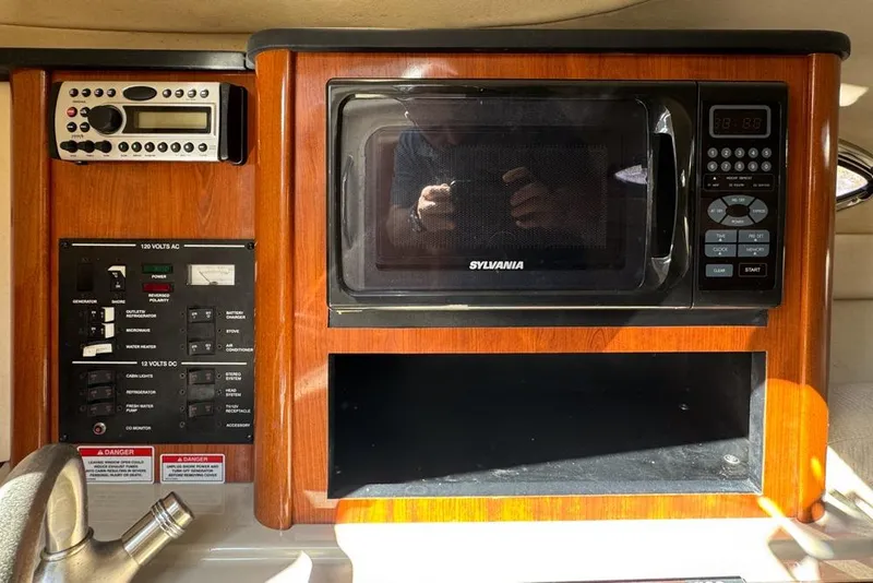 Slide: The Image of 2007 Sea Ray 240 Sundancer interior with microwave and control panel. - 68