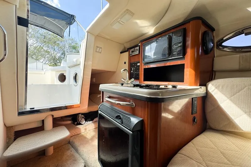 Slide: The Image of Interior of 2007 Sea Ray 240 Sundancer boat with kitchenette and seating area. - 72