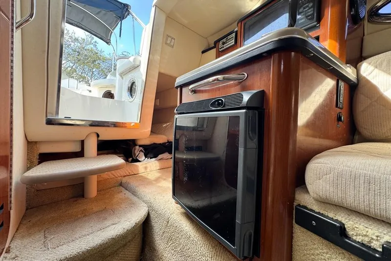 Slide: The Image of Interior of 2007 Sea Ray 240 Sundancer boat, featuring compact kitchenette and seating area. - 73
