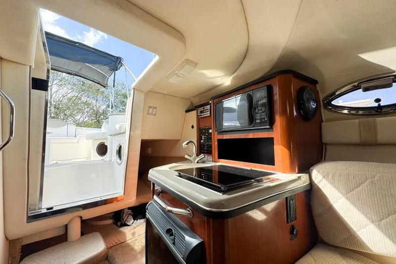 Slide: The Image of Interior of 2007 Sea Ray 240 Sundancer boat with kitchenette and seating area. - 74