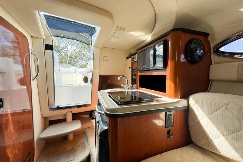 Slide: The Image of 2007 Sea Ray 240 Sundancer cabin interior with kitchenette and seating area. - 77