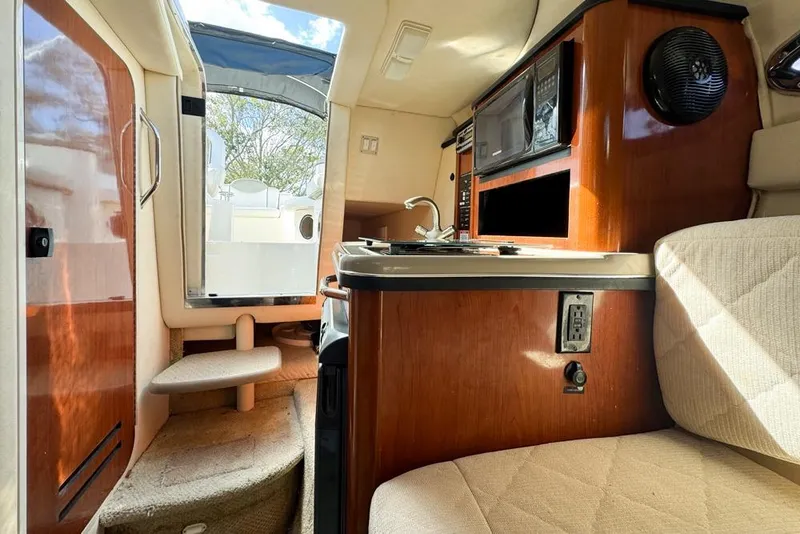 Slide: The Image of Interior of 2007 Sea Ray 240 Sundancer boat, featuring kitchenette and seating area. - 78