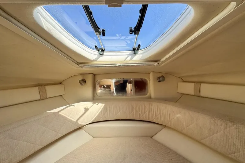 Slide: The Image of Interior cabin of 2007 Sea Ray 240 Sundancer with skylight and beige upholstery. - 87
