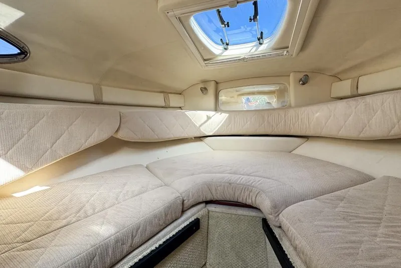 Slide: The Image of 2007 Sea Ray 240 Sundancer cabin interior with beige upholstery and overhead hatch. - 89
