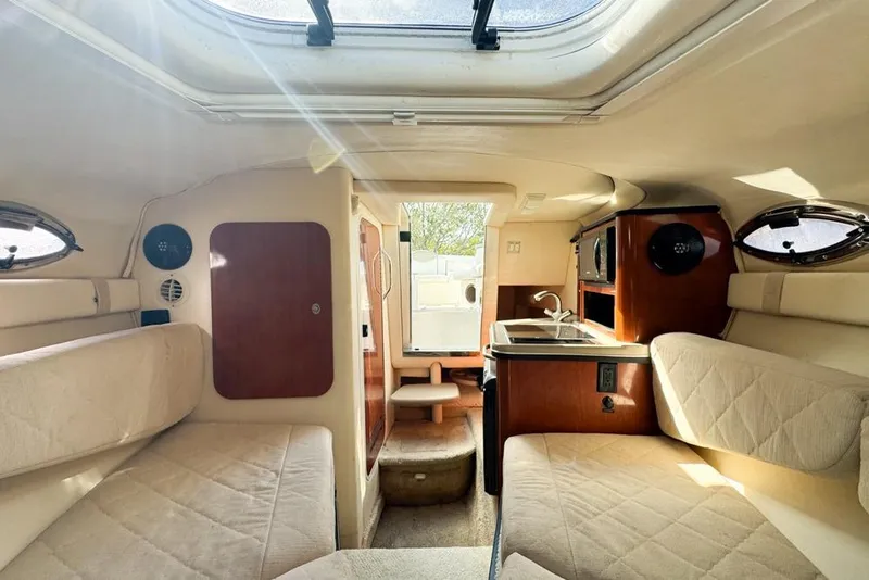 Slide: The Image of 2007 Sea Ray 240 Sundancer cabin interior with seating, kitchenette, and natural light. - 94