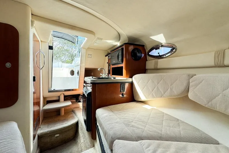 Slide: The Image of Interior of 2007 Sea Ray 240 Sundancer boat, featuring cozy seating and compact kitchenette. - 95