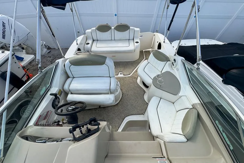 Slide: The Image of 2007 Sea Ray 240 Sundancer boat interior with white seating and steering wheel. - 98