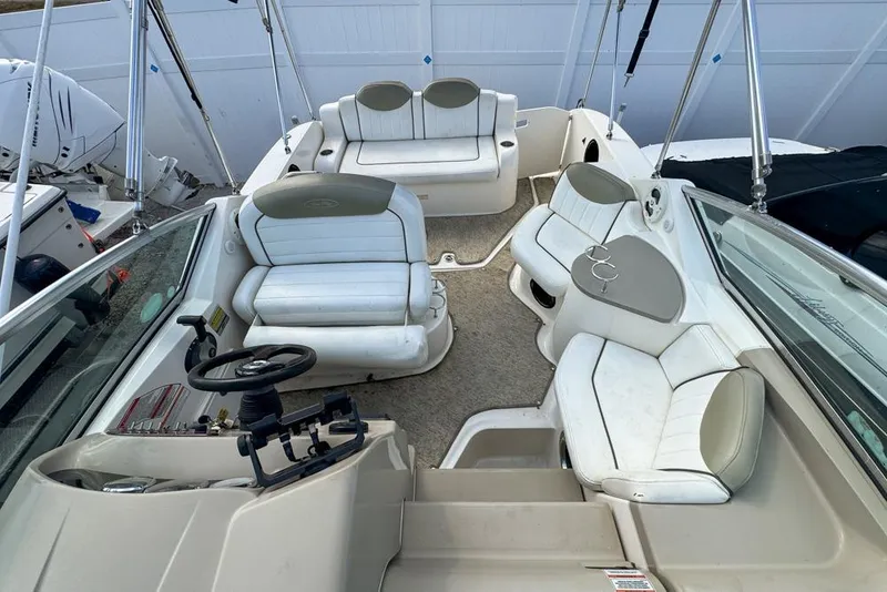 Slide: The Image of 2007 Sea Ray 240 Sundancer boat interior with white seating and steering console. - 99