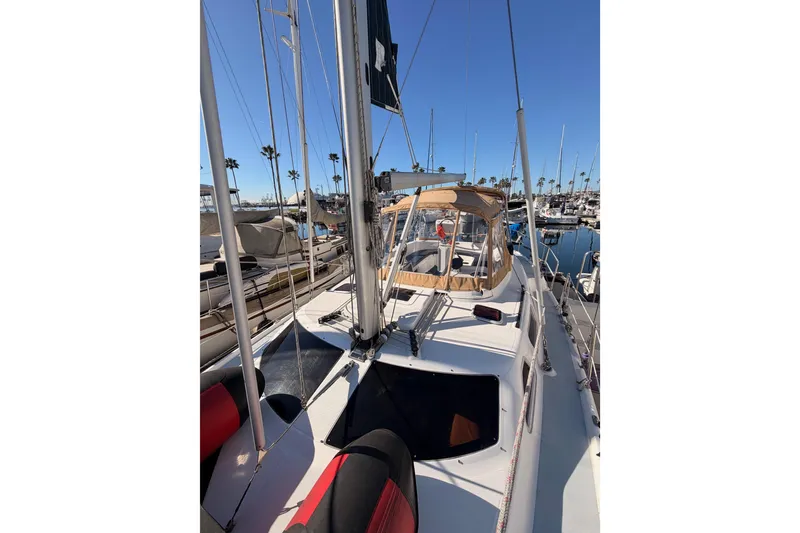 Slide: The Image of 2005 Hunter Passage 456 sailboat docked in a sunny marina, showcasing deck and rigging. - 20