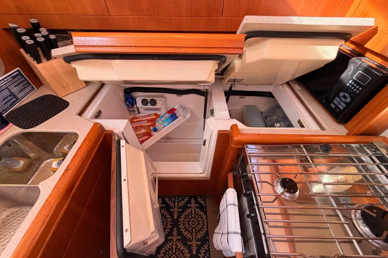 Slide: The Image of 2005 Hunter Passage 456 yacht kitchen with open fridge, stove, and sink. - 38