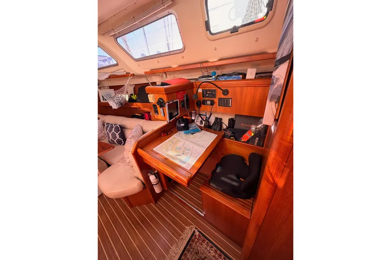 Slide: The Image of Interior of 2005 Hunter Passage 456 sailboat with navigation station and cozy seating. - 44