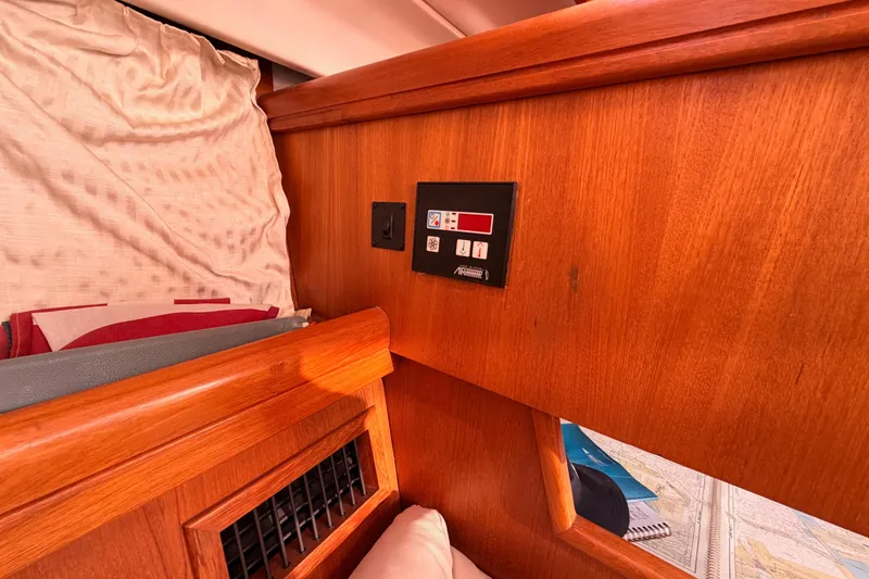 Slide: The Image of Interior of 2005 Hunter Passage 456 yacht with wooden paneling and control panel. - 65