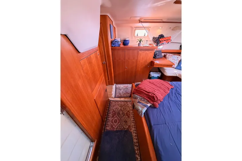 Slide: The Image of Interior of 2005 Hunter Passage 456 yacht with wooden cabinetry and cozy bedding. - 77