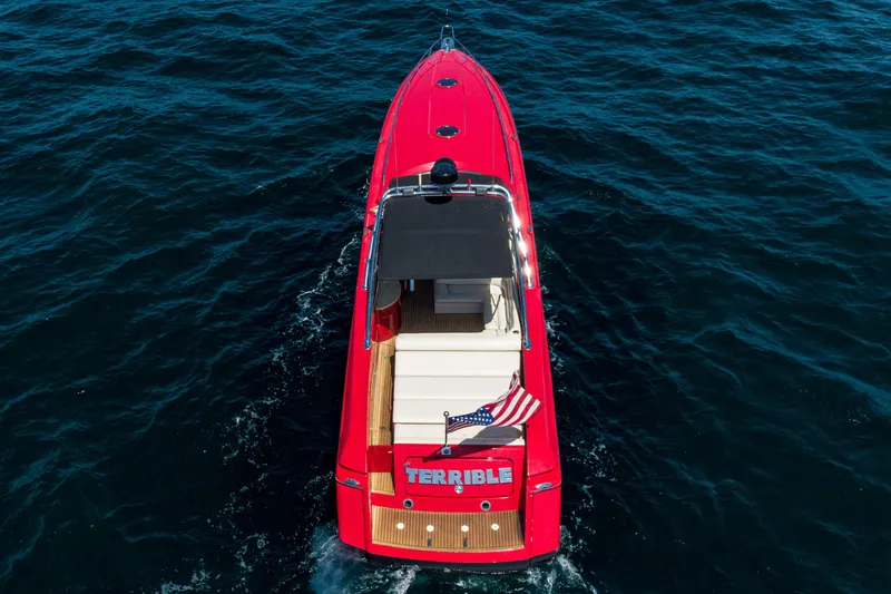 Slide: The Image of Red 2002 Hallett Custom High Performance Express Cruiser on open water, rear view with American flag. - 1