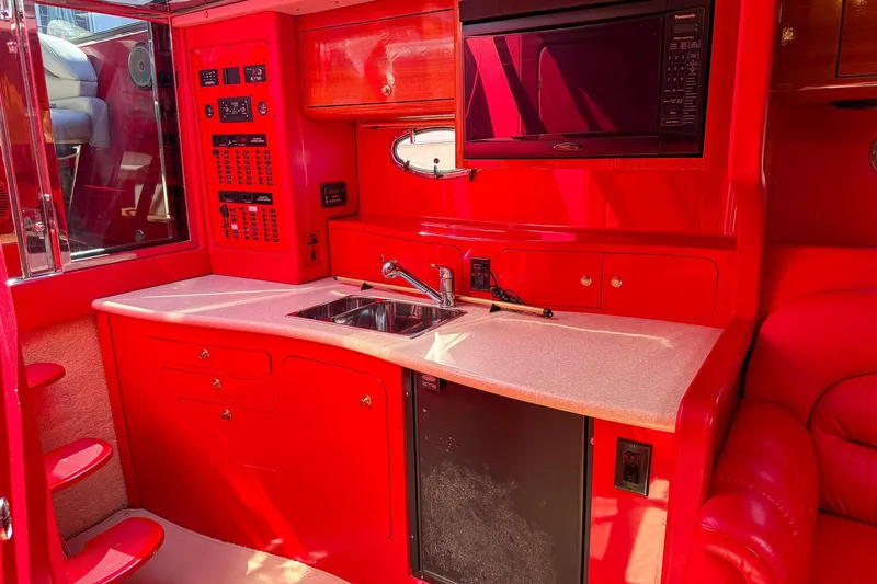 Slide: The Image of Red interior of a 2002 Hallett Custom High Performance Express Cruiser with kitchenette and microwave. - 17