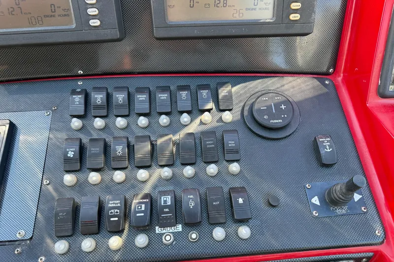 Slide: The Image of Control panel of a 2002 Hallett Custom High Performance Express Cruiser with various switches and gauges. - 23