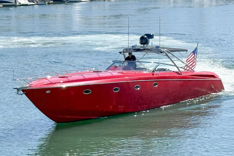 Slide: The Image of Red 2002 Hallett Custom High Performance Express Cruiser on water with American flag. - 48