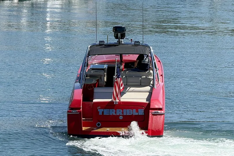 Slide: The Image of Red 2002 Hallett Custom High Performance Express Cruiser on water, rear view with American flag. - 53