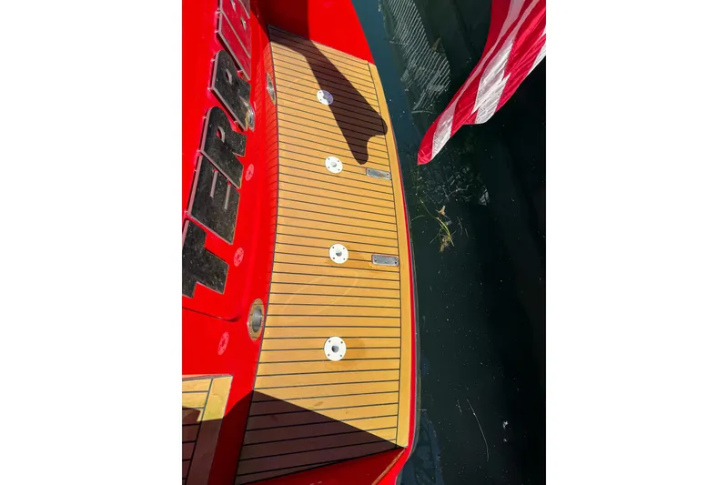 Slide: The Image of Red 2002 Hallett Custom High Performance Express Cruiser with teak deck and American flag. - 59