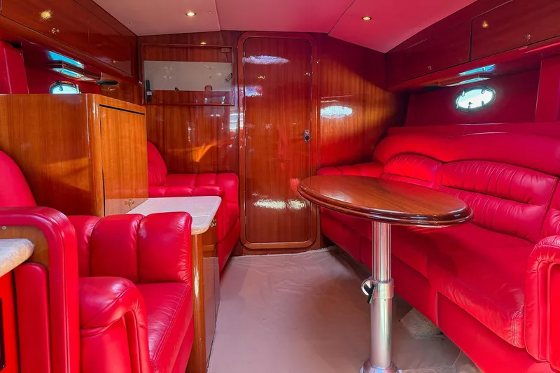 Slide: The Image of Luxurious red interior of 2002 Hallett Express Cruiser with plush seating and wooden accents. - 6