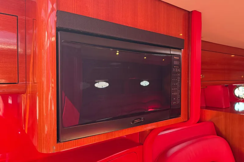 Slide: The Image of 2002 Hallett Express Cruiser interior with built-in Panasonic microwave, red and wood finish. - 64