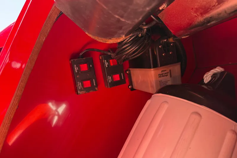 Slide: The Image of Red interior of a 2002 Hallett Express Cruiser showing control switches and fluid container. - 77
