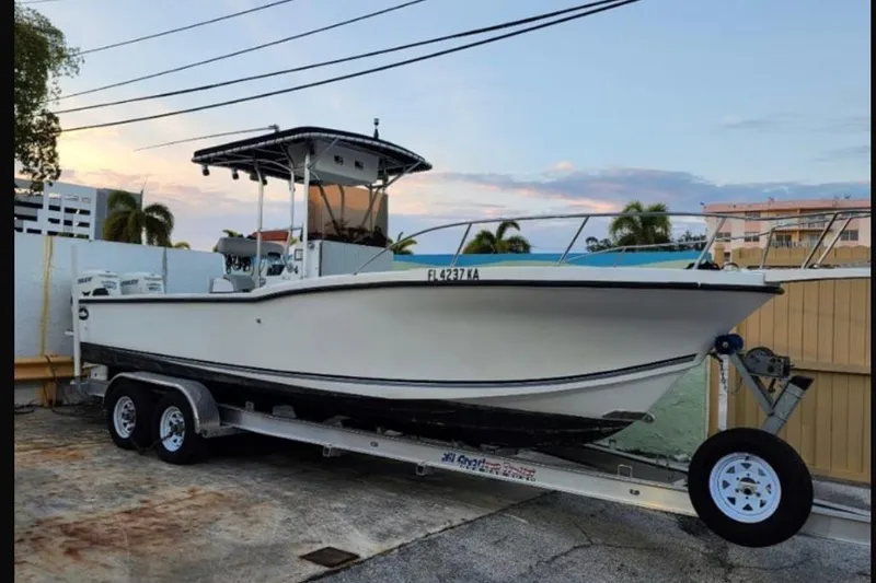 The Image of Dusky 256 CC 1997 boat on trailer, parked outdoors at sunset. - 0