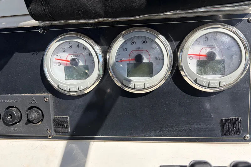 Slide: The Image of Dashboard of a 1997 Dusky 256 CC boat with three gauges and controls. - 4