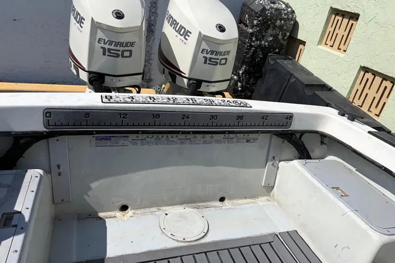 Slide: The Image of 1997 Dusky 256 CC boat with dual Evinrude 150 engines, featuring a measuring ruler. - 6