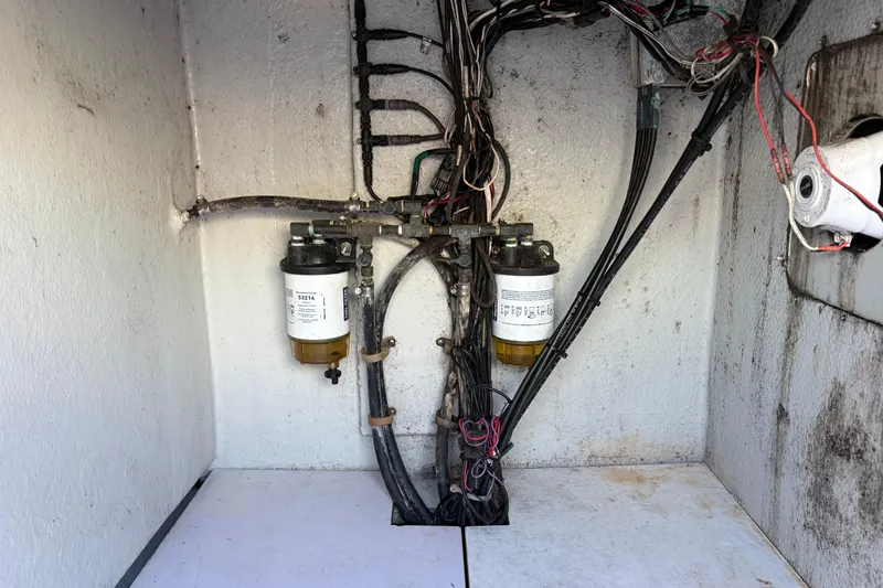 Slide: The Image of Electrical wiring and fuel filters inside a 1997 Dusky 256 CC boat compartment. - 13