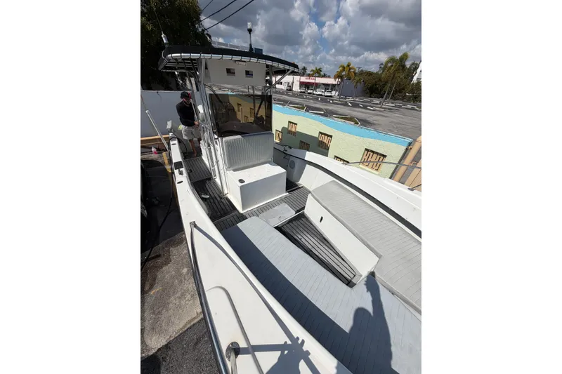 Slide: The Image of 1997 Dusky 256 CC boat with T-top, docked under a cloudy sky. - 21