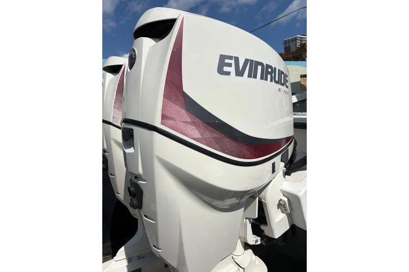 Slide: The Image of Evinrude E-TEC outboard motor on a 1997 Dusky 256 CC boat, under clear blue sky. - 8
